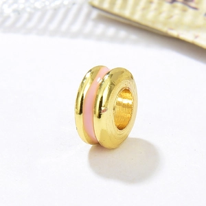Macro shot of 18k gold plated spacer bead with pink enamel for DIY jewelry making