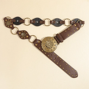 Détail d'une ceinture en cuir marron bohème avec boucle métallique et rivets