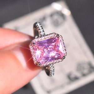 Macro shot of princess cut pink crystal ring with halo yellow diamonds and pavé band