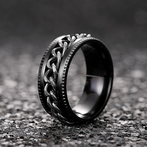 Macro shot of rotatable black stainless steel chain ring with industrial gear texture