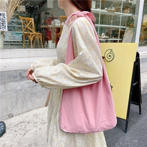 Detailed view of pink canvas tote bag with a unique bow knot shoulder strap design