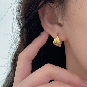 Minimalist 925 sterling silver twisted hoop earrings in gold finish worn by a model