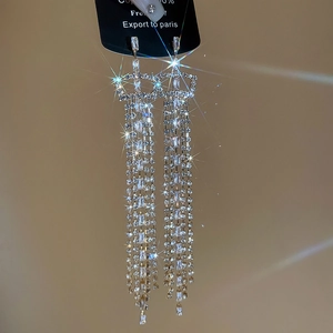 Macro detail of silver long fringe earrings with sparkling zircons and starburst glow