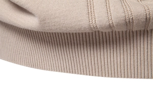 Detailed macro view of the premium ribbed knit cuff and hem on a beige wool sweater
