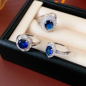 Close-up of zircon hollow flower rings with sapphire blue stones in silver finish