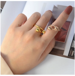 Detailed shot of minimalist gold and rose gold ball rings worn on hand for styling