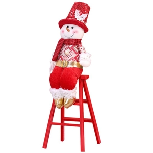 Christmas snowman doll with red sequin hat sitting on decorative red wooden stairs