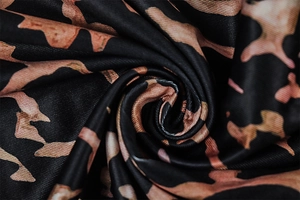 Detailaufnahme von Leopardenmuster-Stoff mit weicher Strickstruktur und braunen Flecken