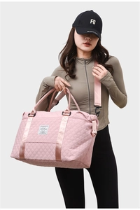 Close-up of pink quilted travel bag with satin finish and adjustable shoulder strap