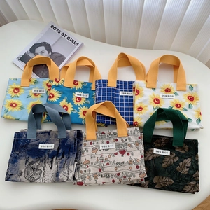Flat lay of diverse mini canvas lunch bags with various floral and geometric patterns