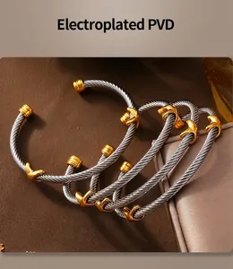 Detail of twisted cable steel bracelets with gold accents and PVD plating finish