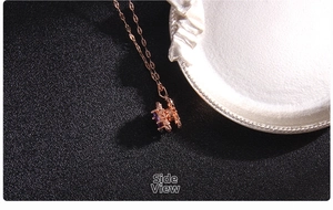 Detailed side view showing rose gold prong setting and purple zircon on clover pendant