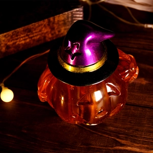 Détail du bougeoir citrouille d'Halloween avec chapeau de sorcier sur fond bois foncé