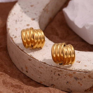 Macro shot of gold-plated 18K stainless steel earrings with layered vertical textures