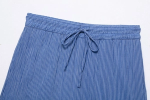 Détail macro du pantalon plissé à rayures bleues montrant la taille élastique à cordon