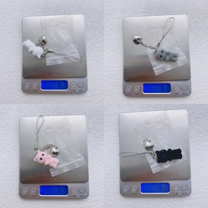 Detailed view showing the lightweight 6.2g flocked cat keychain pendants on a digital scale