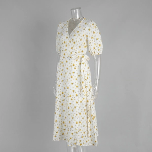 Détail de robe portefeuille à fleurs avec col en V, lien à la taille et manches bouffantes