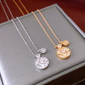 Exquisite gold and silver plated starburst necklaces with zircon stones on gray box