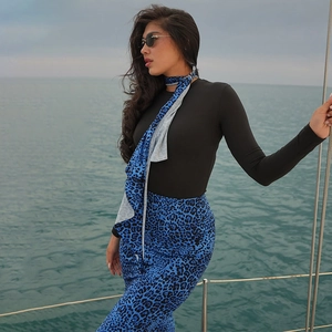 Detail of blue leopard print pants and matching scarf on a luxury yacht deck by the sea