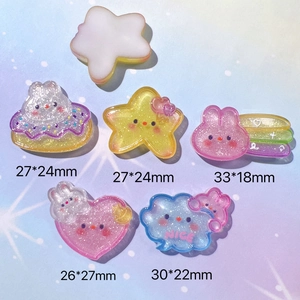 Flat lay of colorful glitter resin charms in star, bunny, and cloud shapes for DIY crafts