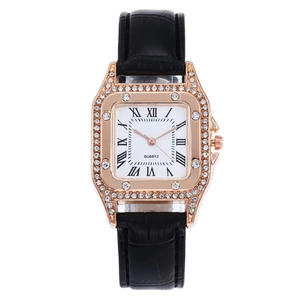 Macro detail of square rose gold watch with crystal bezel and black Roman numerals