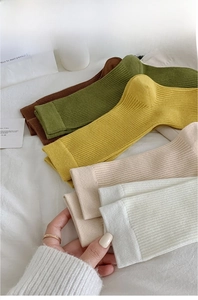 Detailed view of high-count yarn ribbed socks in brown, green, beige, and cream white