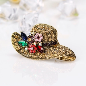 Elegant vintage gold sun hat brooch with colorful rhinestones and crystals on ice background