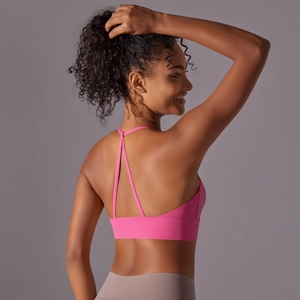 Bright pink sports bra with cross back straps and wide elastic band for yoga and running