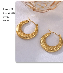 Detail shot of U-shaped gold earrings featuring 18k gold plated textured grid pattern