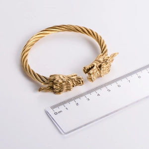 Detail view of 18k gold-plated dragon head bangle measuring 7cm diameter on a ruler