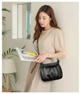 Modern black pleated hobo bag with textured leather and soft shoulder strap detail