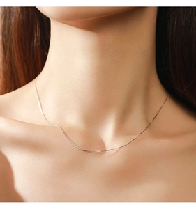 Close-up of minimalist S925 sterling silver heart necklace on a model's neck