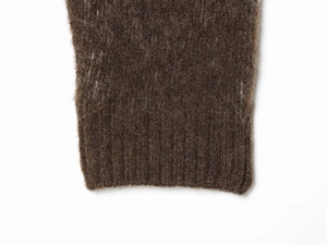 Close-up of the fuzzy dark brown knit fabric with fine texture and ribbed cuff detail