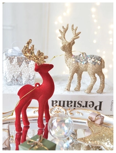Detail of red flocked reindeer and golden glitter deer hanging Christmas ornaments