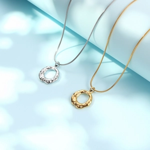 Irregular hollow ring pendant necklace with hammered metal texture in gold and silver finish
