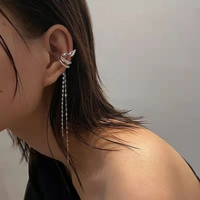 Silver multi-layer ear cuff featuring long metallic tassels on a model's ear