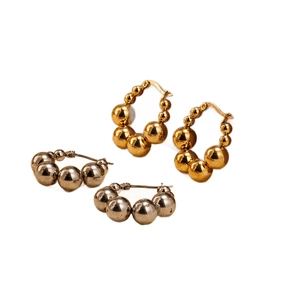 Geometric stainless steel ball hoop earrings in gold and silver finish on white background