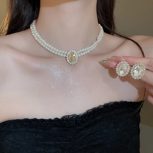 Detail of elegant double-layer pearl necklace with oval zircon pendant on a fashion model