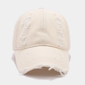 Détail de la casquette beige avec effet usé vintage et bords effilochés sur la visière