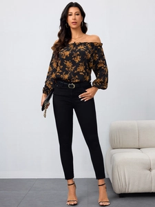 Detail der schulterfreien Blumenbluse mit schwarzer Skinny-Jeans und Gürtel-Kombi