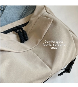 Close-up of beige canvas dumpling bag showing durable black zipper and woven pullers