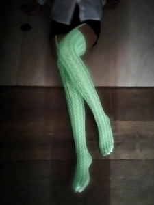 Gros plan sur les chaussettes montantes vert clair lumineuses avec tricot à torsades