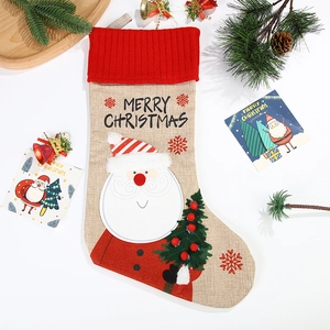 Linen Christmas stocking with Santa Claus and tree embroidery on festive background