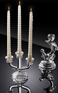 Detailed view of 3-arm glass candle holder and dolphin stand on mirrored surface