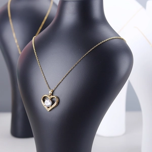 Elegant gold heart necklace with zircon stone on a mannequin bust jewelry display