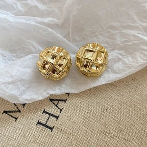 Detailed view of gold round button earrings featuring a 3D embossed quilted lattice texture