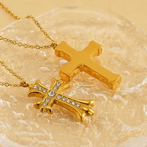 Luxurious gold-plated cross necklace and rhinestone cross pendant on glass tray