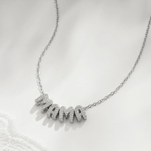 Macro shot of silver MAMA letter pendant with sparkling zircons on a thin chain necklace
