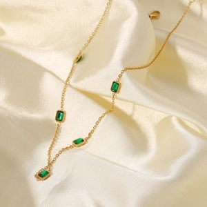 Détail d'un collier plaqué or 14K avec cinq zircons rectangulaires vert émeraude