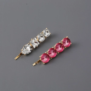 Detail shot of two elegant gold and silver hair clips with sparkling rhinestones